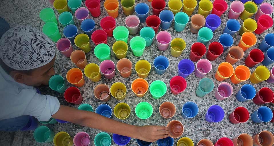 On the first day of Ramadan, a boy in India arranges glasses of water before Iftar, the meal Muslims eat to break their dawn-to-dusk fast -- Jaipal Singh/Photolibrary &copy; (Bing United States)