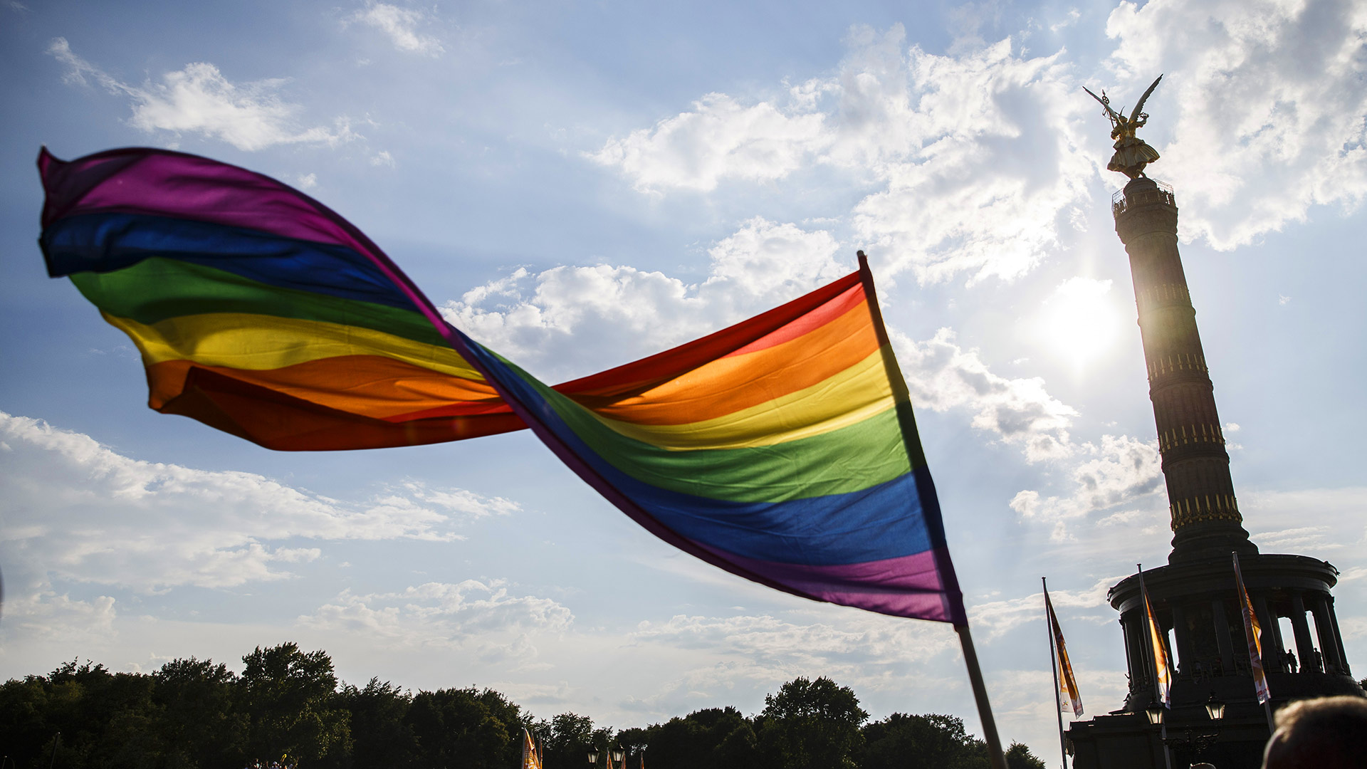 Ein Teilnehmer schwenkt die Regenbogen-Flagge auf dem 40. Christopher Street Day vor der Siegessäule am 28. Juli 2018 in Berlin, Deutschland (© Carsten Koall/Getty Images News)(Bing Deutschland)