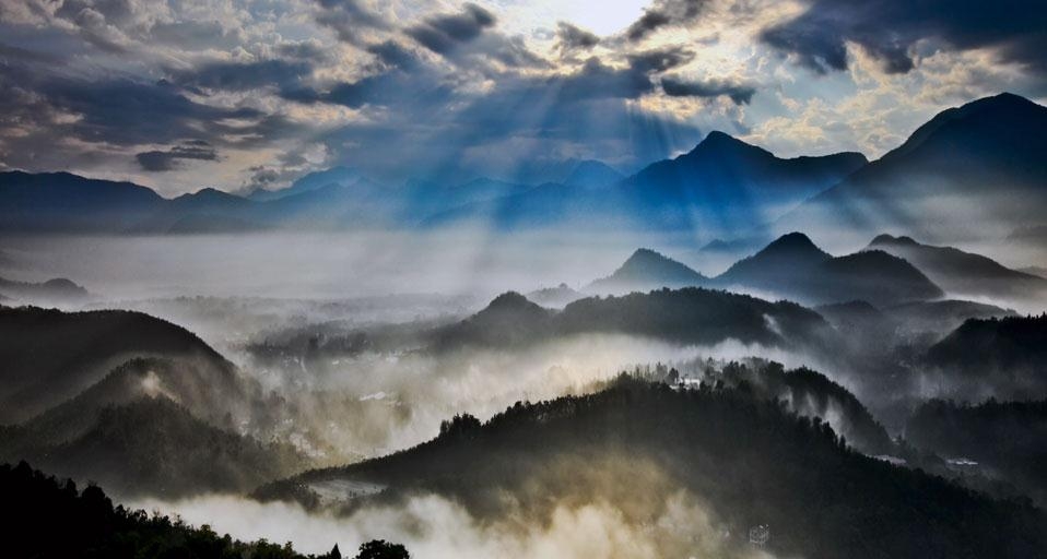 Sun rays slanting into misty valleys below conical peaks in Nantou County, Taiwan (© Artbeats/Baoying Multimedia Technologies Inc.) &copy; (Bing United Kingdom)