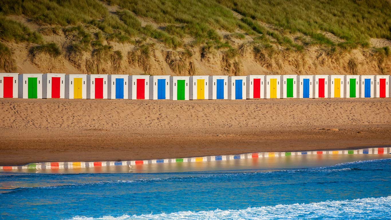 Beach huts reflecting in the water at Woolacombe Beach, Devon (© Fingerszz/Getty Images)(Bing United Kingdom)