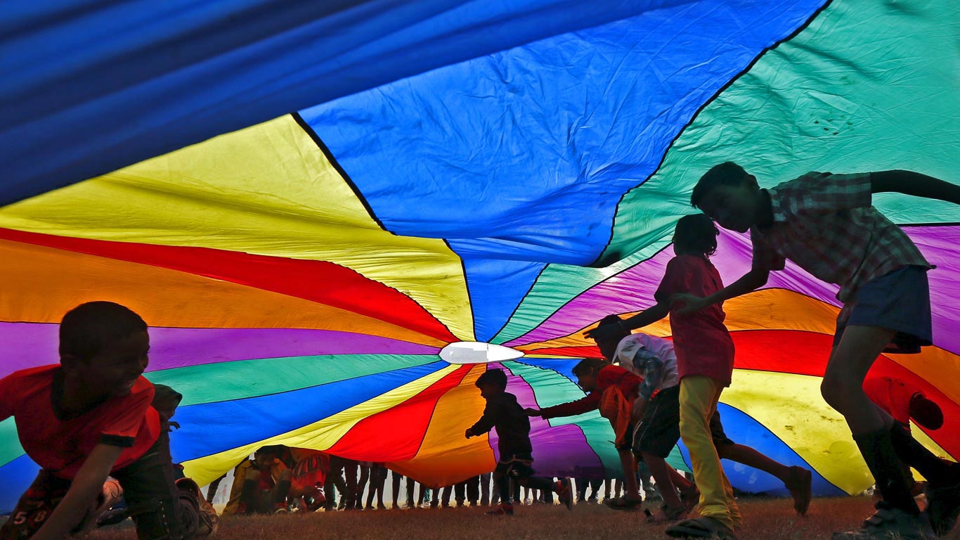 Children play under a parachute in Kolkata, India, for International Day of Friendship (© Rupak De Chowdhuri/Reuters)(Bing United Kingdom)