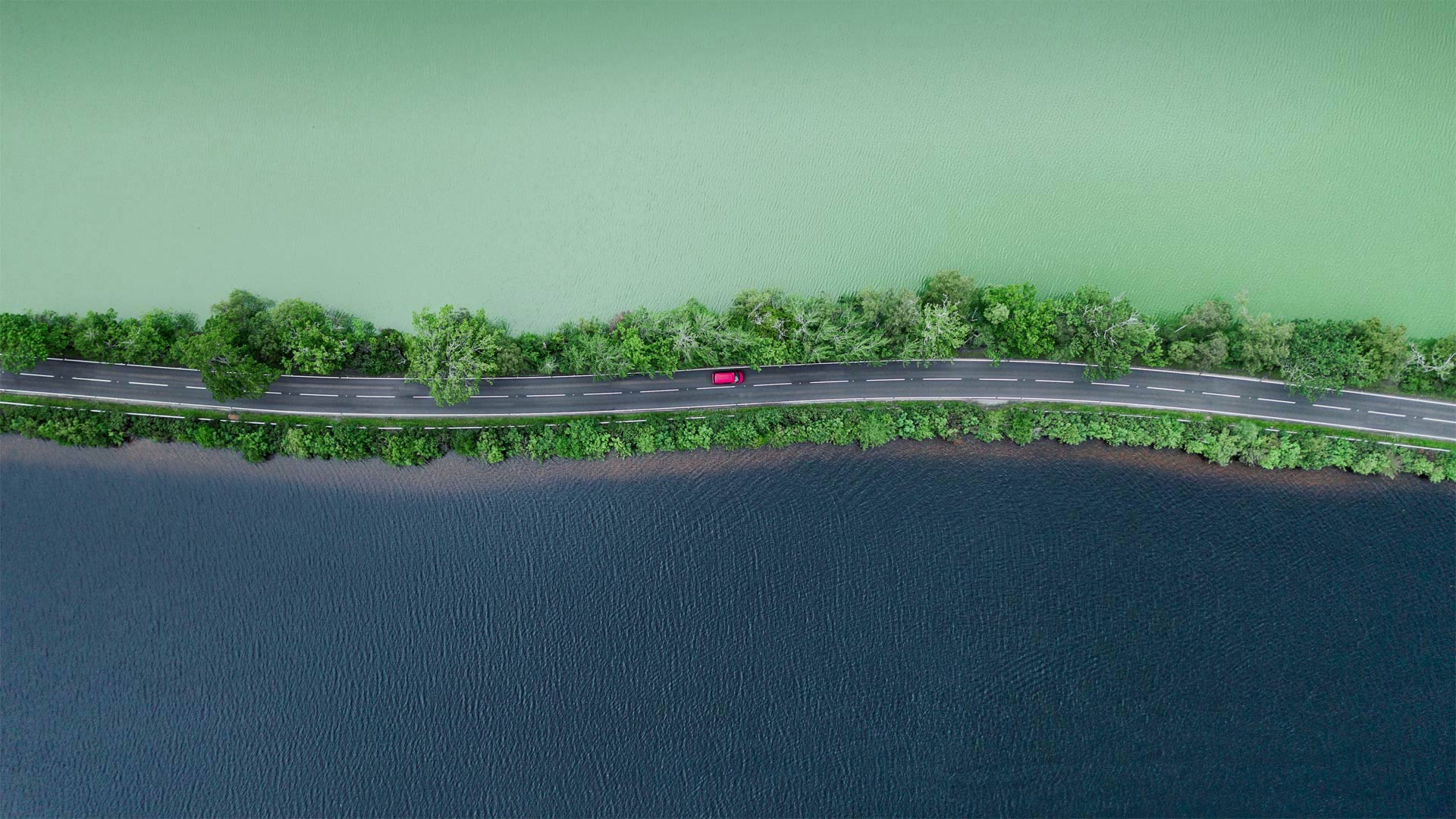 Luftaufnahme einer Straße, die zwei Seen im schottischen Hochland trennt (© Abstract Aerial Art/Getty Images)(Bing Deutschland)