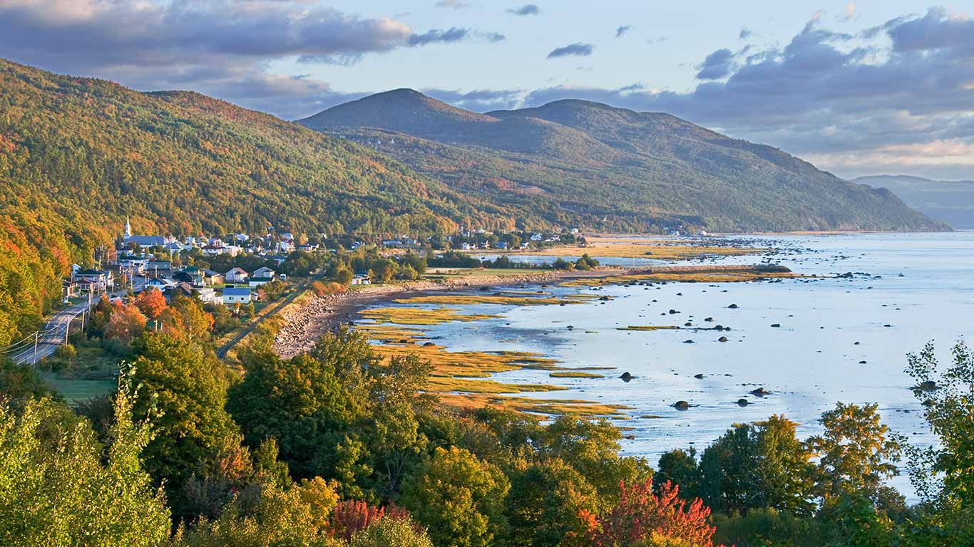 Village nestled between mountains and the St. Lawrence River, Charlevoix, Que. (© Robert Chiasson/Getty Images)(Bing Canada)