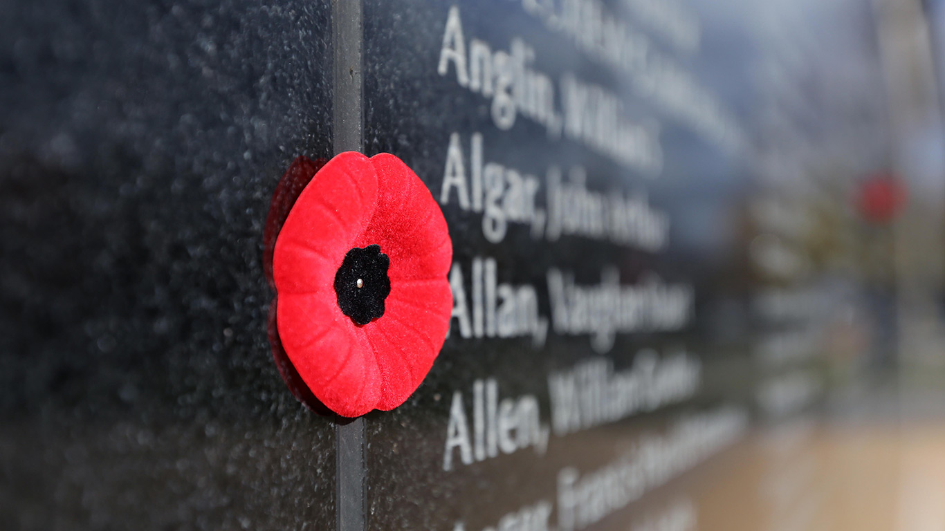 Poppies sit by names on a memorial wall during Remembrance Day in Kingston, Ont. (© Lars Hagberg/Alamy Stock Photo)(Bing Canada)