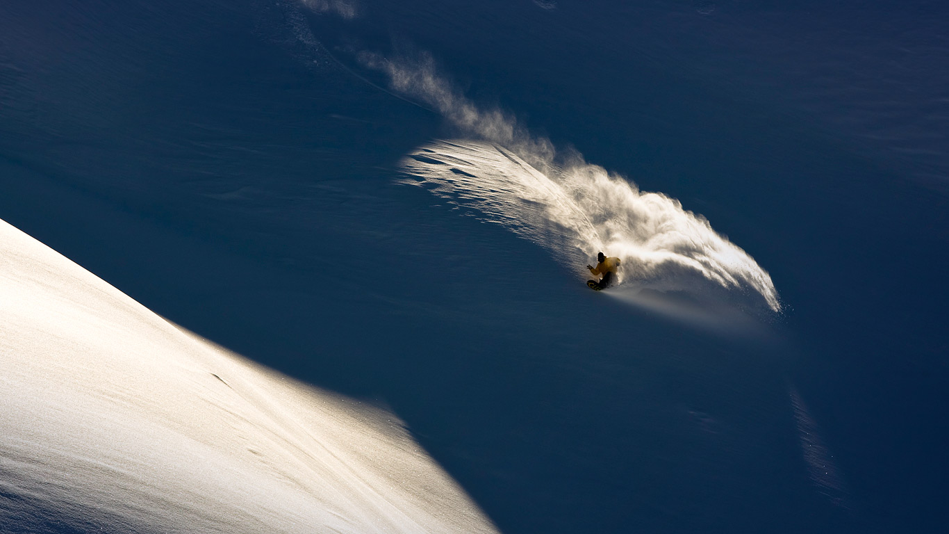 Snowboarder makes powder turn in backcountry terrain (© Jeff Curtes/Aurora Photos)(Bing United Kingdom)