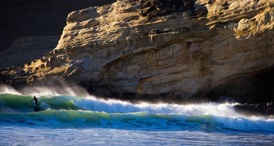 Surfer riding a wave near Pacific City, Oregon, U.S.A. (© Gabe Rogel/Aurora Photos) &copy; (Bing Canada)