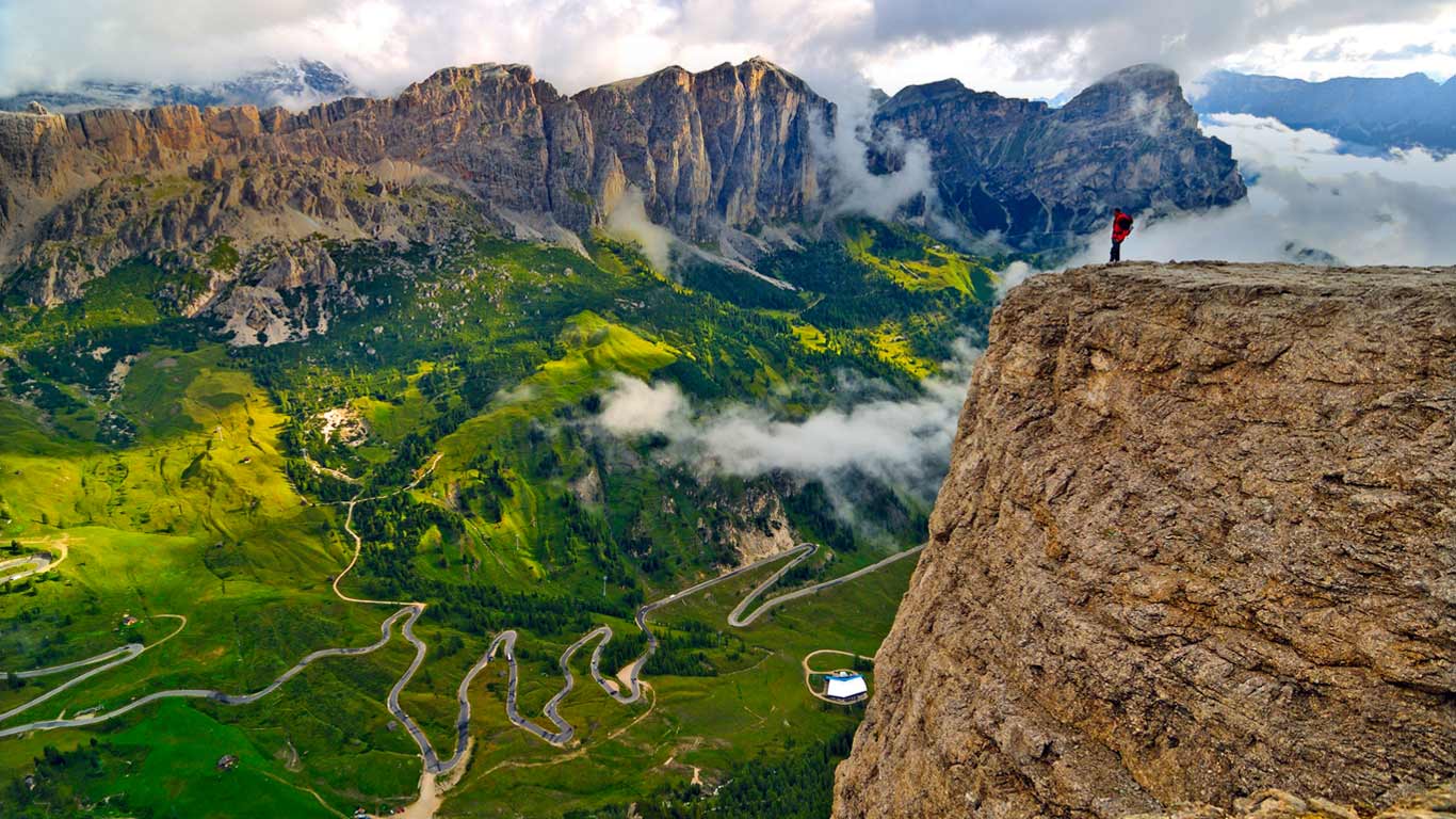 Trekker on the Sella Group mountain chain, looking down on the road from Badia Valley to Gardena Pass, Dolomites, South Tyrol, Italy (© SIME/eStock Photo)(Bing United Kingdom)