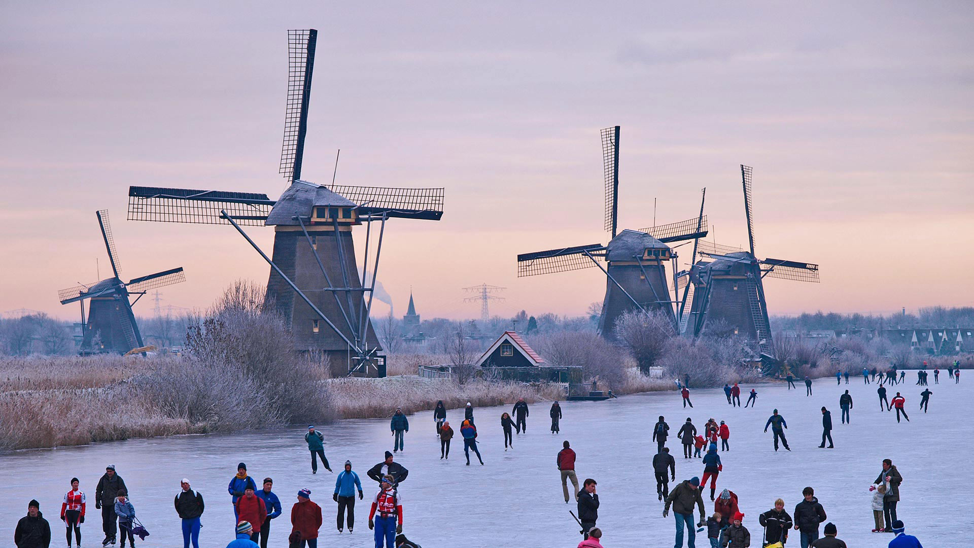 Skating on a frozen canal near the windmills at Kinderdijk in the Netherlands (© Lourens Smak/Alamy)(Bing Canada)