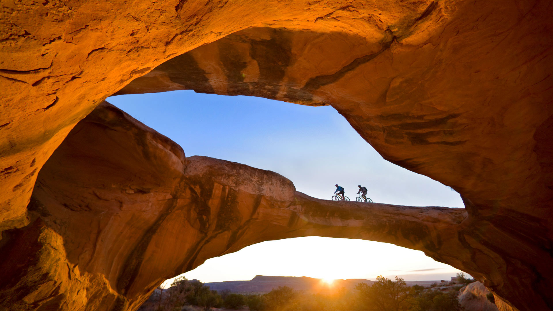 Cycling across a natural rock arch in the desert near Moab, Utah, USA (© Whit Richardson/Cavan)(Bing United Kingdom)