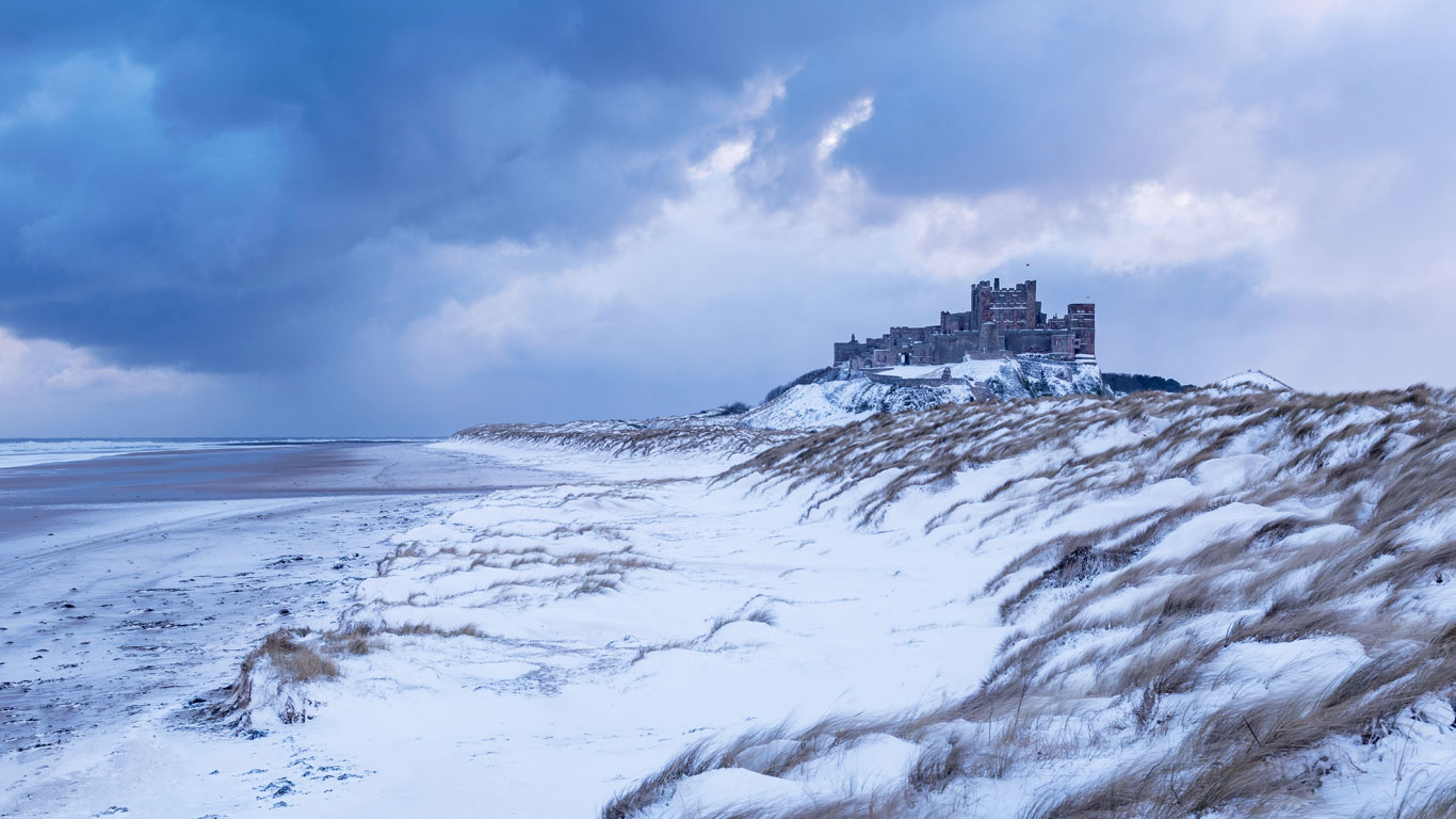 Bamburgh Castle and sand dunes after snowfall in Northumberland (© Ross Hoddinott/Minden Pictures)(Bing United Kingdom)