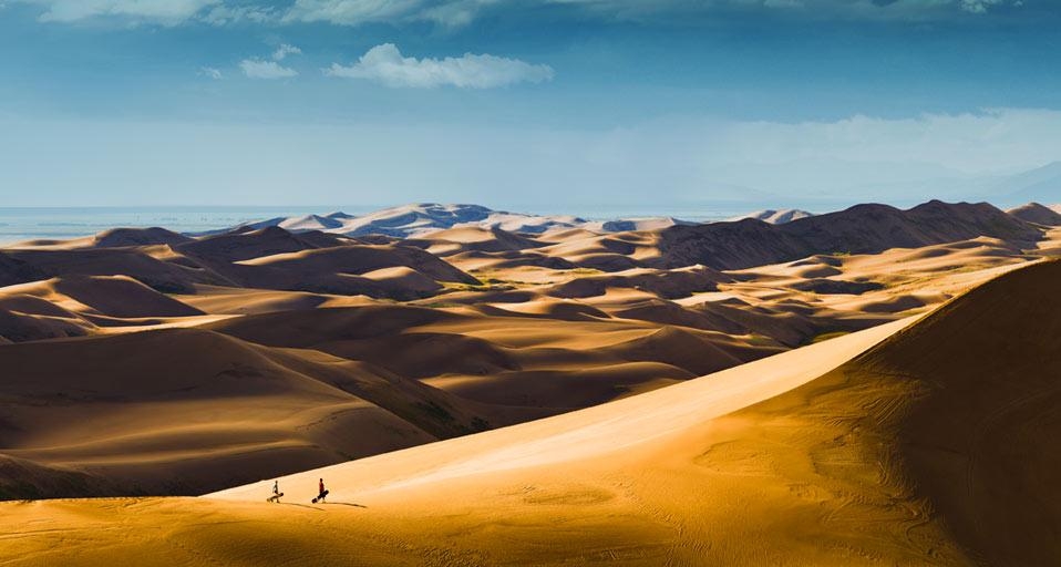 Sandboarders hiking up dunes for another ride, Great Sand Dunes National Park, Colorado, USA (© Glenn Oakley/Aurora Photos) &copy; (Bing United Kingdom)