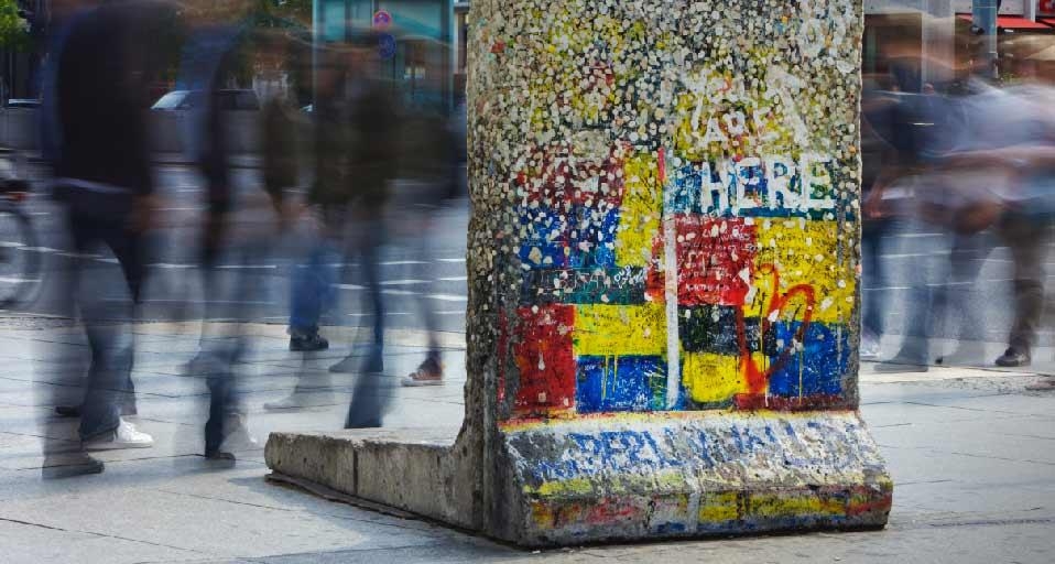 Berliner Mauerdenkmal am Potsdamer Platz. Passanten laufen an einem einzelnen Segment der Berliner Mauer am Potsdamer Platz vorbei, welches an seiner ursprünglichen Position belassen wurde und nun als Denkmal dient. (© Jon Hicks/Corbis) &copy; (Bing Germa