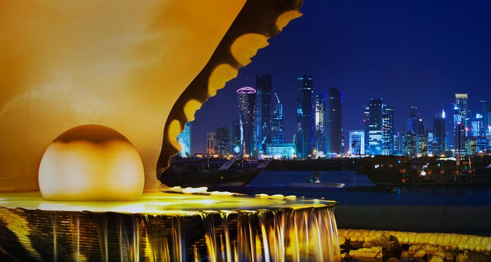 The pearl monument in the Corniche neighbourhood of Doha, Qatar, illuminated at night with the new high-rises of West Bay in the background -- Jon Hicks/Corbis &copy; (Bing United Kingdom)